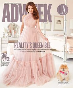 a woman in a pink dress standing next to a dog on the cover of a magazine