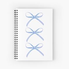 a spiral notebook with blue bows on it