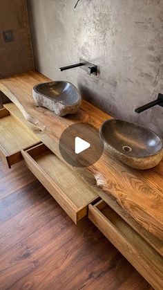 two bowls are sitting on a table with wood and metal fixtures in the bathroom area