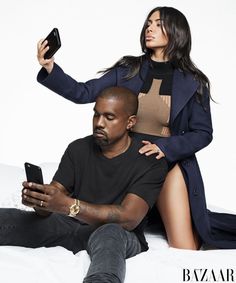 a man sitting on the ground next to a woman who is holding a cell phone