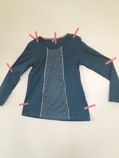 a blue shirt with pink pins sticking out of it