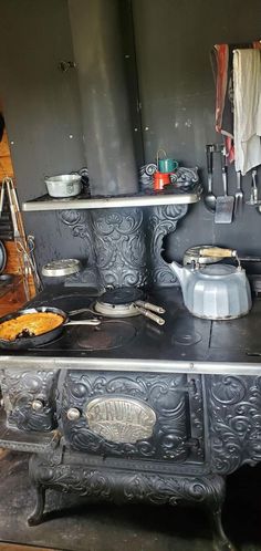 an old fashioned stove with pots and pans on it