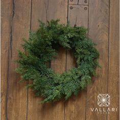 a green wreath sitting on top of a wooden floor