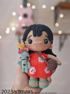 a small crocheted doll is holding two stuffed animals in it's hand