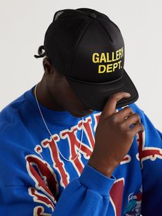 Workwear has been bleeding into menswear since the 1990s, becoming crisper, polished and more refined. Gallery Dept.'s 'Trucker' cap is made from black foam and has a breathable mesh construction. It's printed with a bold yellow moniker on the front. Gallery Dept, Guys Clothing Styles, Cap Men, The 1990s, Clothing Styles, Black Logo, Trucker Cap, Logo Print, Caps Hats