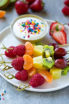 fruit skewers are arranged on a white plate