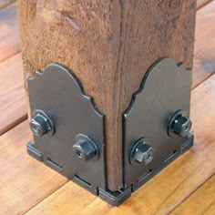 a close up of a wooden object on a wood floor with metal handles and rivets