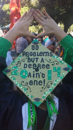 a person wearing a green and black graduation cap with the words 99 problems buy a degree