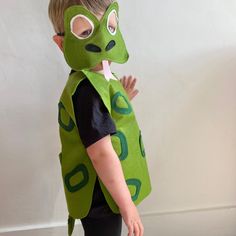 a young boy wearing a costume made to look like a frog