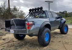 the truck is parked on the side of the road with blue wheels and tire rims