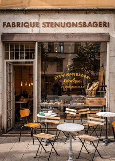 tables and chairs in front of a store window