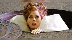 a woman laying on the ground wearing a tiara