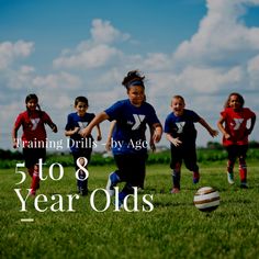 a group of young children kicking around a soccer ball on top of a green field