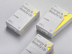 three boxes with yellow labels on them sitting next to each other in front of a gray background