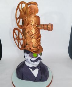 a statue of a man with a golden camera on top of it's head