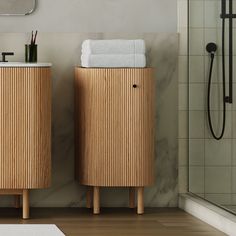 two wooden cabinets with towels on them in a bathroom