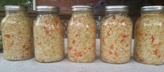 four jars filled with rice sitting on top of a table