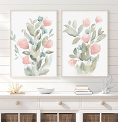 two watercolor flowers are on the wall above a white table with wicker baskets