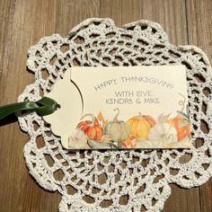 a white doily with a card on it that says happy thanksgiving, with pumpkins and gourds