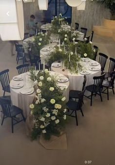 the table is set with white flowers and place settings for guests to sit down at