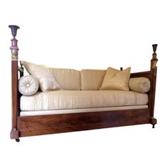 a wooden couch with pillows on top of it