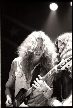 black and white photograph of two people playing guitars