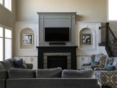 a living room filled with furniture and a flat screen tv mounted on the wall above a fireplace