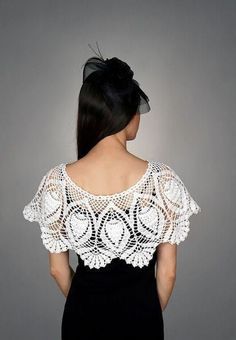 the back of a woman wearing a white crochet top and black skirt, with her hands on her hips