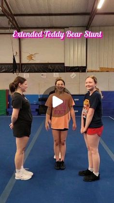 three girls standing in a gym talking to each other with the caption extended teddy bear stunt