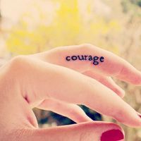 a woman's hand with the word courage written on it