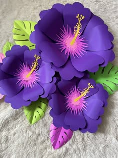 purple paper flowers with green leaves on a white background