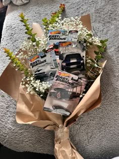 a bouquet of flowers is wrapped in brown paper and sits on the floor next to magazines