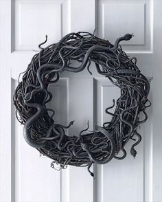 a wreath is hanging on the door with vines around it and an insect crawling inside