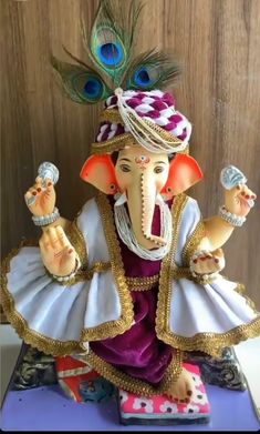 an elephant figurine with a peacock on it's head