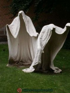 two white cloth covered chairs sitting in the grass