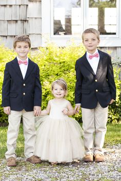 two young boys in tuxedos and bow ties posing for a photo with their sister