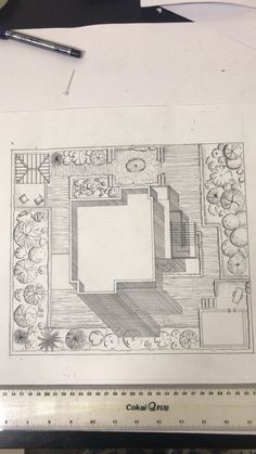 a drawing of a garden design on top of a table next to a ruler and pen