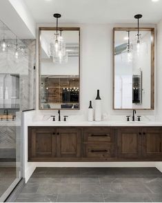 a bathroom with two sinks and mirrors on the wall