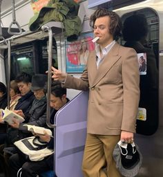 a man in a suit standing on a subway train