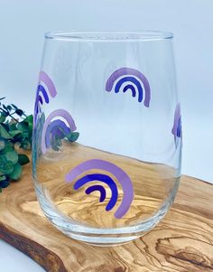 a glass sitting on top of a wooden cutting board next to a potted plant