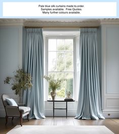 a living room filled with furniture and a large window covered in blue drapes