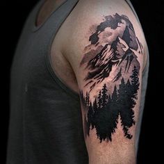 a man's arm with a mountain and trees tattoo on the left side of his arm