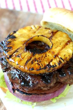 a grilled pineapple burger on a bun with lettuce and onions