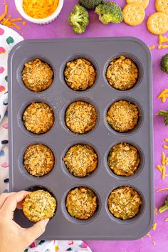 muffins in a muffin tin with broccoli and carrots on the side