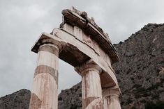 an old stone structure in front of a mountain