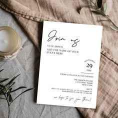 a white wedding card on top of a table next to a cup and saucer