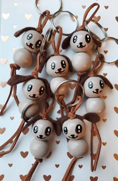 a bunch of key chains that have some kind of pandas on them with hearts in the background