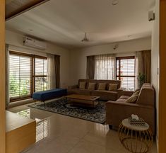 a living room filled with furniture and windows covered in blinds on top of it's sides