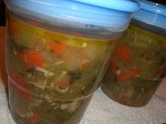 two plastic containers filled with soup sitting on top of a table