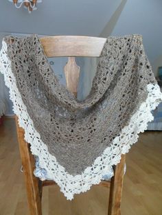 a wooden chair with a crocheted shawl on it